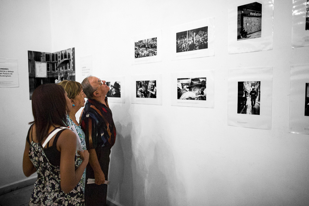 Picture of the frames on the exhibition wall with the caption and also Gallery Attendants at "Londres. Detrás y debajo del palacio de buckingam" exhibition space. gallery arte soy in santiago de cuba, cuba. 2015  © Pedro Rodrigues